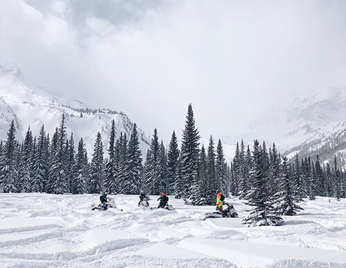 Winter scene with people on snowmobiles.