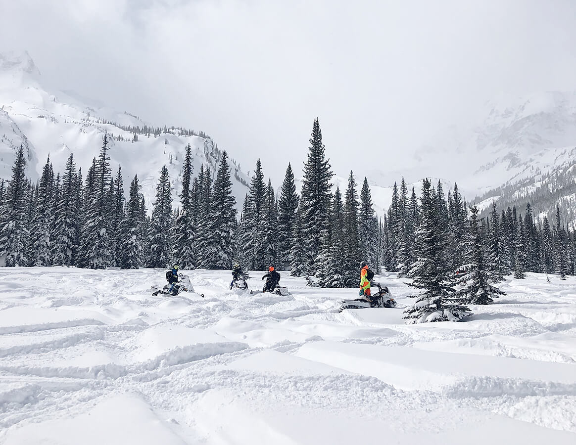 Winter scene with people on snowmobiles.