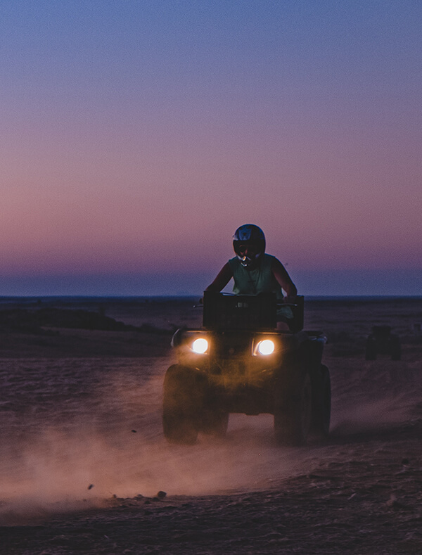 Person riding an ATV at dusk.